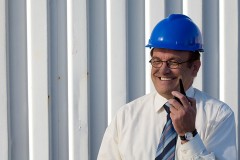 an industrial engineer wearing a blue hard hat, talking on a radio